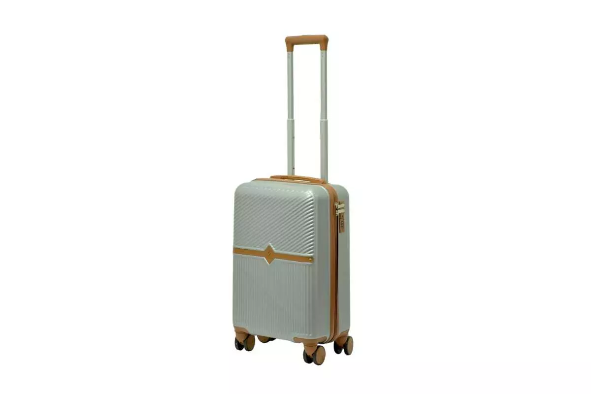 20 inch silver hard shell luggage with a tan accent band and top handle, side view with four wheels