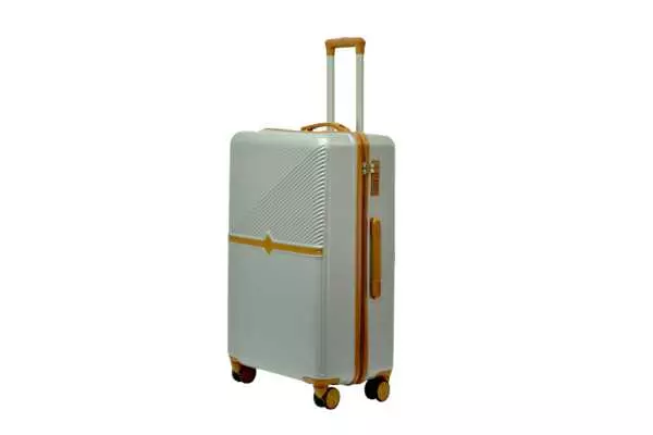 28 inch silver hard shell luggage with a tan accent band and top handle, side view with four wheels